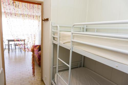 une chambre avec deux lits superposés et une table dans l'établissement Grau du Roi - Los Amigos II, au Grau-du-Roi