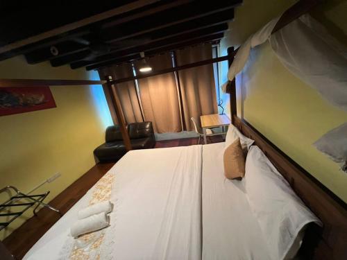 a bedroom with a large white bed in a room at Hotel Lang Hoose in George Town