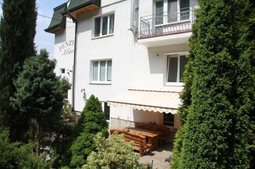 un edificio blanco con árboles delante de él en Villa Anastazis - Penzion Eden, en Karlovy Vary