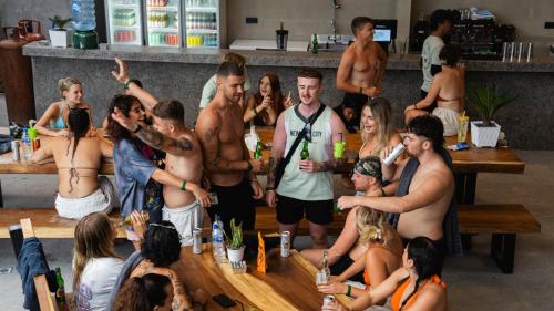 a group of men and women standing in a bar at The Farm Nusa Party Hostel in Nusa Penida