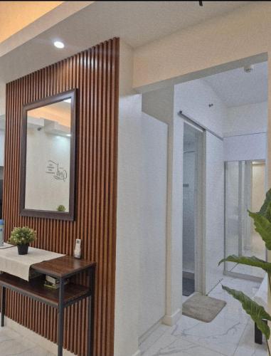 ein Badezimmer mit Spiegel und Holzwand in der Unterkunft Modern Minimalist 1BR Condotel at BGC Taguig in Taguig
