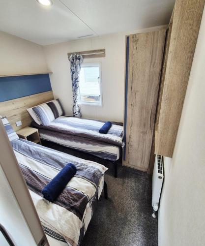 a small room with two beds in it at New 2 bed holiday home with decking in Rockley Park Dorset near the sea in Lytchett Minster