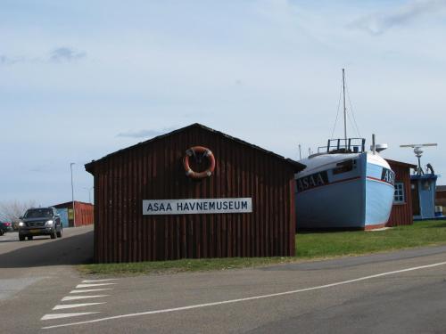 a building with a boat on the side of a road at Asaa Camping & Cottages in Aså