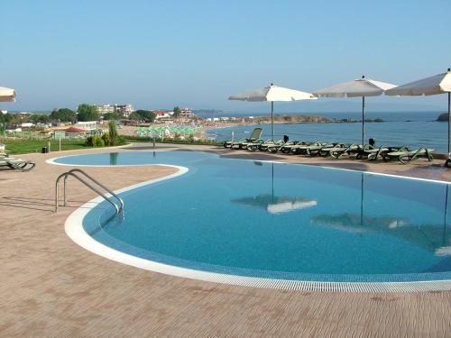 una piscina con sedie e ombrelloni vicino all'oceano di Samara Apartment a Lozenets