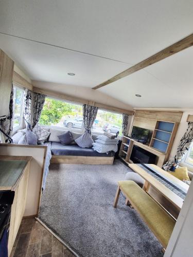 a living room with a couch and a table at New 2 bed holiday home with decking in Rockley Park Dorset near the sea in Lytchett Minster