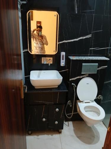 齐拉克普尔Hotel Golden Rooftop的浴室里有洗手池、马桶和镜子。