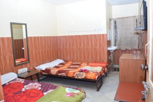 a room with two beds and a mirror at HOTEL S-A-V-I-T-R-I PALACE Near Shree Baba Baidyanath Jyotirlinga - Free Wifi And Parking Facilities - Spacious and Fully Air Conditioned Rooms-Budget Hotel in Deoghar