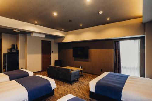 a hotel room with two beds and a television at 慶 -Kei- HOTEL LIKE RESIDENCE in Fukuoka