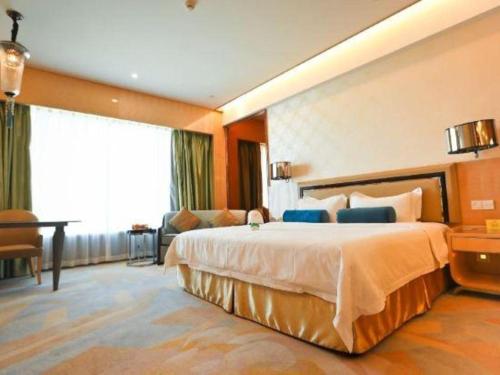a hotel room with a large bed and a desk at Shanghai Fuyue Hotel in Shanghai