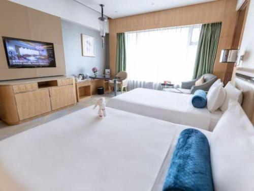 a hotel room with two beds and a television at Shanghai Fuyue Hotel in Shanghai