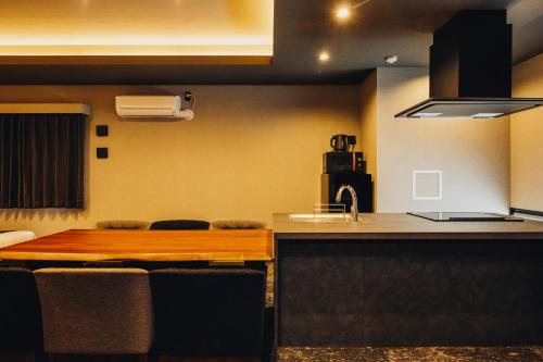 a kitchen with a wooden table and a counter at 慶 -Kei- HOTEL LIKE RESIDENCE in Fukuoka