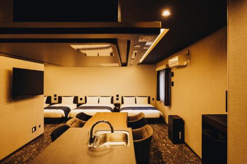a hotel room with four beds in a row at 慶 -Kei- HOTEL LIKE RESIDENCE in Fukuoka