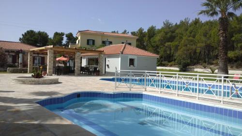 a large swimming pool in front of a house at Zeus Hotel in Iraion