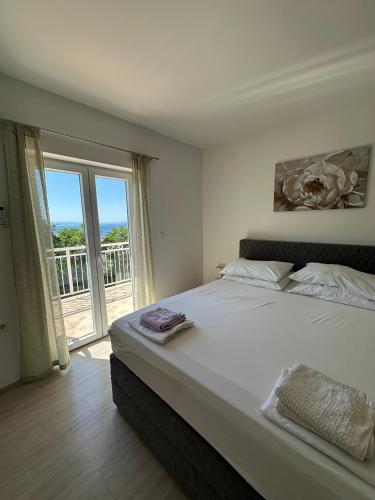 a bedroom with a large bed and a large window at Bobo App in Senj