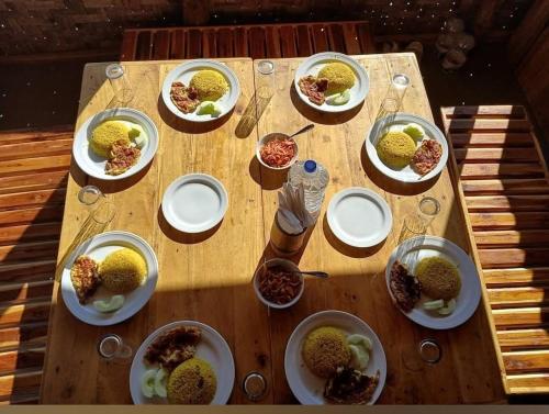 a wooden table with plates of food on it at Giri Raj Resort Bandarban in Bāndarban