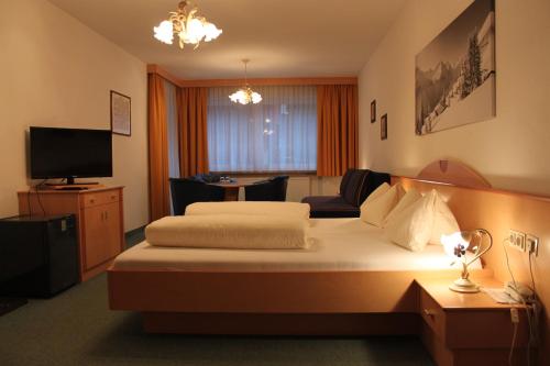 ザンクト・アントン・アム・アールベルクにあるHaus Roman Falchのベッド2台とテレビが備わるホテルルームです。