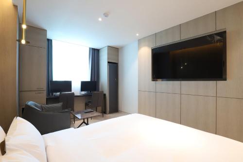 a hotel room with a bed and a flat screen tv at Hound Hotel Asan Terminal in Asan