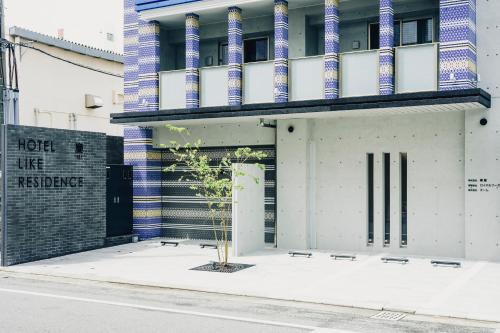 a building with a tree in front of it at 慶 -Kei- HOTEL LIKE RESIDENCE in Fukuoka