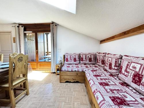 une chambre avec quatre lits avec des couettes rouges et blanches dans l'établissement Les Chalets Des Evettes - Appartement vue montagnes dans une résidence avec piscine MAE-3104, à Notre-Dame-de-Bellecombe