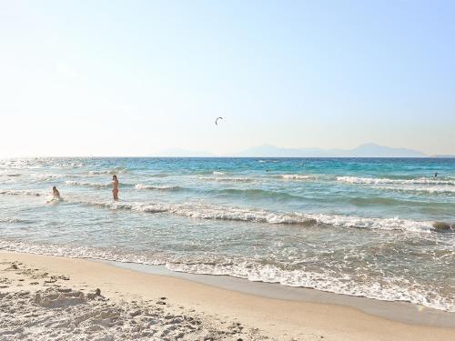 a group of people playing in the water at the beach at Grecotel Casa Paradiso in Marmari