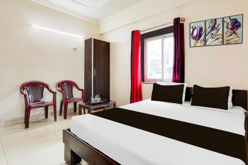 a bedroom with a large bed and two chairs at Hotel O Visakhapatnam Railway Station in Visakhapatnam