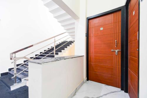 a wooden door in a building with stairs at Hotel O VIP Road Near Golden Beach in Puri