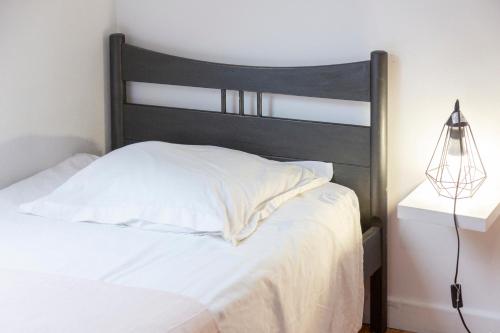 a bedroom with a white bed with a black headboard at Gîte avec piscine-Cap Sizun in Confort