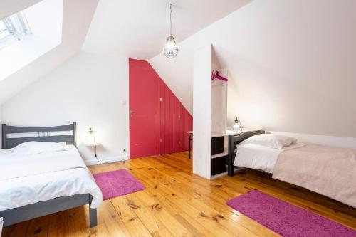 a bedroom with two beds and a red door at Gîte avec piscine-Cap Sizun in Confort