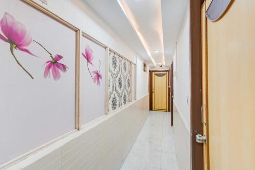 a hallway with pink flowers on the walls at Hotel O Maninagar East in Ahmedabad