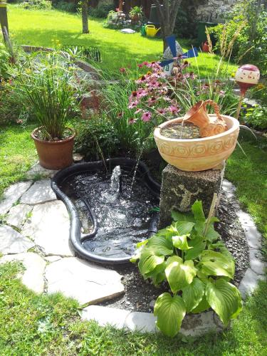 a garden with a fountain and plants in a yard at Haus Sagl in Nauders