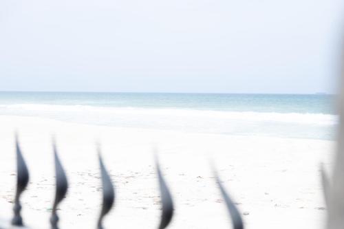 a view of the beach through a window of the ocean at Al Shatti Villas in Salalah