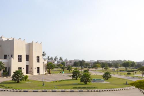 a building with a park in front of it at Al Shatti Villas in Salalah