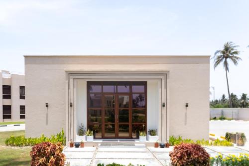 a white building with a door in front of it at Al Shatti Villas in Salalah