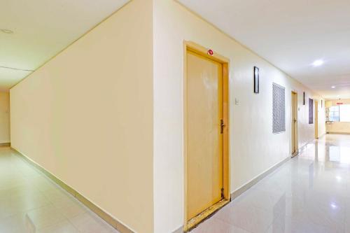 an empty hallway with a yellow door in a building at Hotel O NAD Near Airport in Visakhapatnam