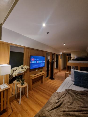 a bedroom with a bed and a flat screen tv at Sunset View Ridge Residences in Baguio