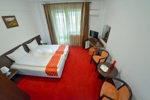 a bedroom with a bed and a red carpet at Pension Happy Day - motorcycle friendly in Sibiu