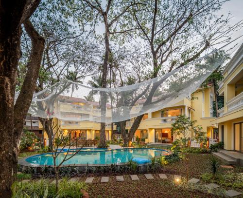 a resort with a swimming pool in front of a building at Kensho Hibiscus 3-BHK Villa With Common Pool, Plunge Pool & Lift Near Popular Beaches in Majorda