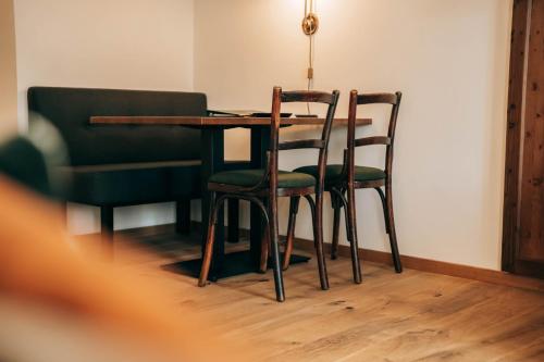 a dining room table with two chairs and a table at Zum Goldenen Löwen in Maria Taferl