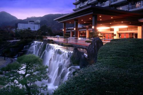 a waterfall in front of a building next to a building at Kinugawa Hotel Mikazuki in Nikko