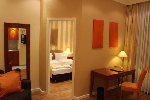 a room with a bedroom with a bed and a mirror at Hotel Savoy Hannover in Hannover