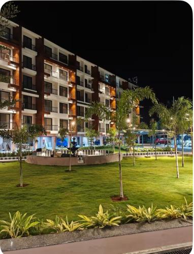 a park with palm trees and buildings at night at Skylands Homes in Calangute