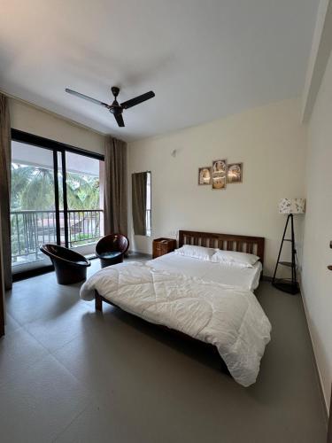 a bedroom with a bed and a ceiling fan at Skylands Homes in Calangute