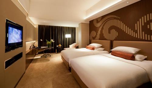 a hotel room with two beds and a flat screen tv at Baiyun Hotel Guangzhou in Guangzhou