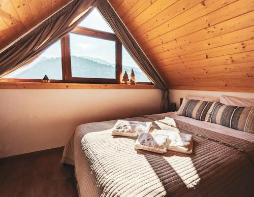 a bed in a room with a large window at Beskidzka Kępa Szczyrk - domek z balią i pięknym widokiem na góry in Szczyrk