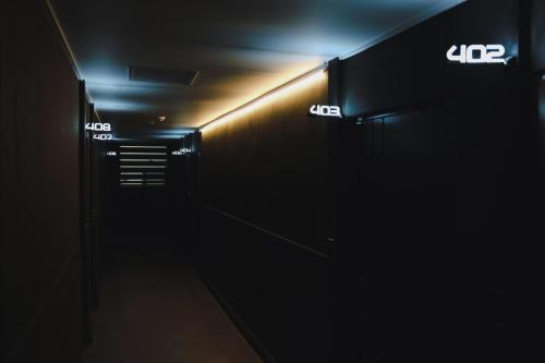 a dark hallway with illuminated signs on the wall at 부천 인생호텔 in Bucheon