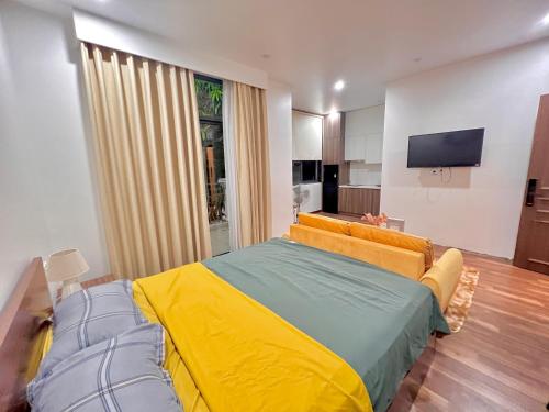 a bedroom with a bed with a yellow and green blanket at HPT Home II Vinhome Marina chuỗi Apartment - Homestay in Hai Phong