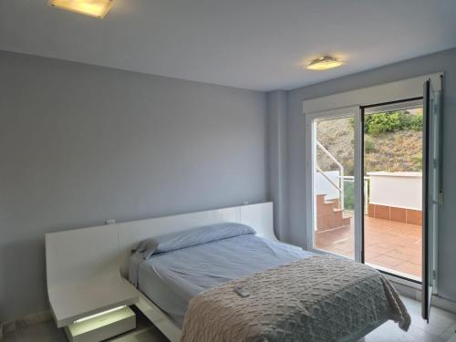 a bedroom with a bed and a sliding glass door at TRIPLEX DE LUJO EN MOJACAR in Mojácar