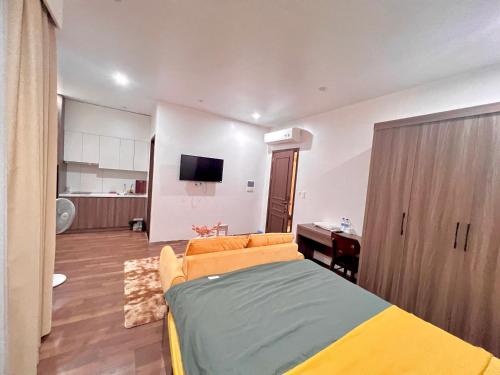 a bedroom with a bed and a couch and a tv at HPT Home II Vinhome Marina chuỗi Apartment - Homestay in Hai Phong