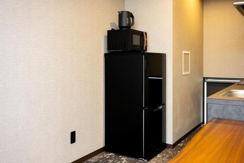 a black refrigerator with a tv on top of it at 慶 -Kei- HOTEL LIKE RESIDENCE in Fukuoka