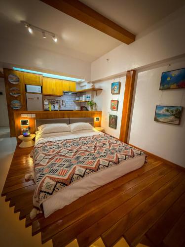 a bedroom with a large bed with a wooden floor at Aqua Horizon Beachside Condo I Signature Art Suites in Dauis